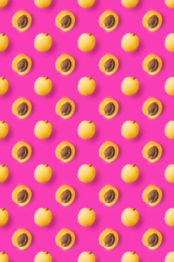 Bir bütün ve parlak pembe arka planda kemikli şeftali. Vejetaryen konsepti. Yaratıcı görüntü, minimalizm, üst görünüm, düz yatak. Lezzetli ve sağlıklı yemekler..