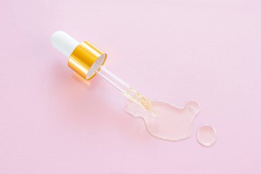 Pembe arka planda doğal yağlı kozmetik pipeti. Organik esansların, güzelliğin ve sağlık ürünlerinin şık bir konsepti. Uzayı kopyala, minimalizm, düz yat. Modern eczacı. 