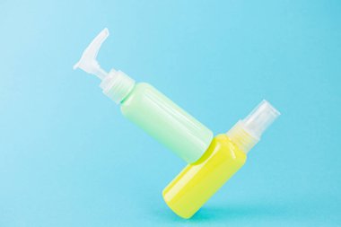 Sarı ve mavi kozmetik şişeleri aynı renk arka planda. Organik esansların, güzelliğin ve sağlık ürünlerinin şık bir konsepti. Boşluğu, minimalizmi, havalanma etkisini kopyala.