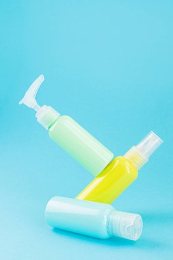 Sarı ve mavi kozmetik şişeleri aynı renk arka planda. Organik esansların, güzelliğin ve sağlık ürünlerinin şık bir konsepti. Boşluğu, minimalizmi, havalanma etkisini kopyala.