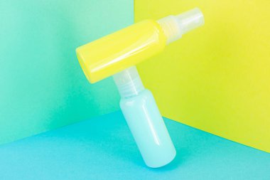 Sarı ve mavi kozmetik şişeleri aynı renk arka planda. Organik esansların, güzelliğin ve sağlık ürünlerinin şık bir konsepti. Boşluğu, minimalizmi, havalanma etkisini kopyala.