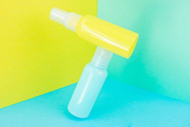 Sarı ve mavi kozmetik şişeleri aynı renk arka planda. Organik esansların, güzelliğin ve sağlık ürünlerinin şık bir konsepti. Boşluğu, minimalizmi, havalanma etkisini kopyala.