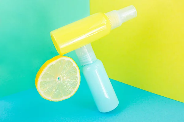 Yellow and blue cosmetic bottles on the same colored background. Stylish concept of organic essences, beauty and health products. Copy space, minimalism, levitation effect.