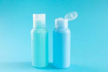 Mavi arka planda mavi kozmetik şişeler. Organik esansların, güzelliğin ve sağlık ürünlerinin şık bir konsepti. Boşluğu kopyala, minimalizm.