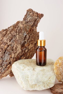 Bir taşın üzerinde doğal bir yağ şişesi, ağaç kabuğunun yanında güzel bir dokuya sahip. Doğal esanslar için konsept, organik kozmetik, aroma terapi, spa.
