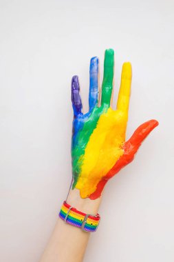 Bir kadının eli boya ve LGBT gökkuşağı renginde bir bilezik ile kaplıdır. Aşk kavramı, cinsel tolerans, LGBT gurur, eşcinsel ilişkiler, homoseksüellik..