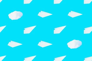Pattern from white paper airplanes and cotton clouds on a blue background. Creative concept of travel, flights.	