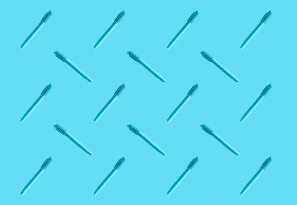 Blue pens lie on a blue background. The concept of training, business, school, office. Minimalism, copy space, pattern.