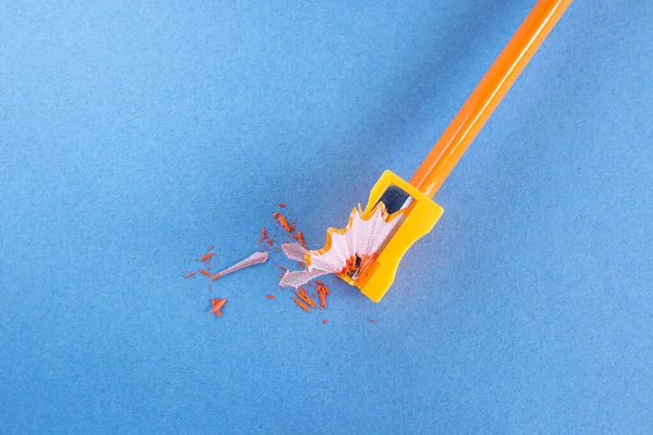 Πορτοκαλί Ξύλινο Μολύβι Ροκανίδια Μια Ξύστρα Χαρτικών Μπλε Φόντο Δημιουργική — Φωτογραφία Αρχείου