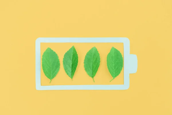 Eco Green Energy Battery Concept. Battery indicator made of paper with leaves. Minimalism, copy space, top view.