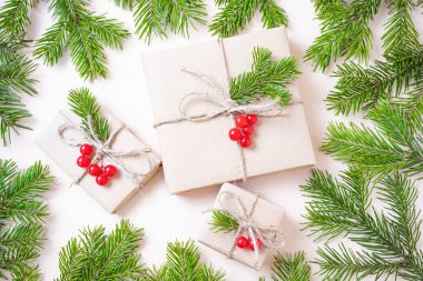 Noel ekosistem düzlüğü: el işi kağıt, ladin dalları ve süs olarak kırmızı böğürtlenlere sarılı hediyeler. Sürdürülebilirlik kavramı.