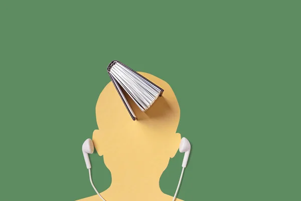 一个男人的头像 旁边是耳机 上面是一本书 有声读物 教学理念 简约主义 复制空间 — 图库照片