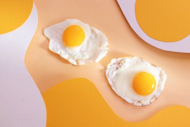 Açık beyaz ve sarı dalgalı arka planda sahanda yumurta. Kağıt sanatı. Kahvaltı konsepti, kızarmış yemek..