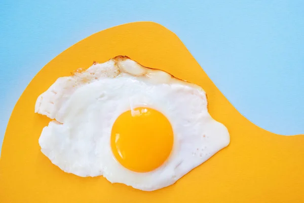 薄いオレンジと青の背景 パターン上の目玉焼き 朝食のコンセプトは 揚げ料理 ミニマリズム トップビュー — ストック写真