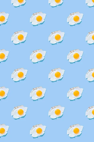 薄い青の背景に目玉焼き パターン ミニマリスト トップビュー 朝食のコンセプト 揚げ料理 — ストック写真