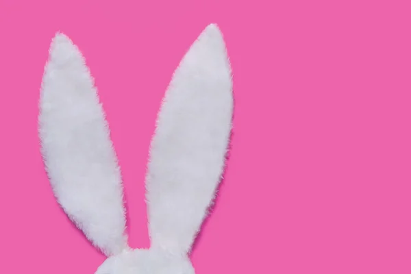 兔子的耳朵由白色毛皮制成在粉红色柔和的背景。复活节的概念 — 图库照片