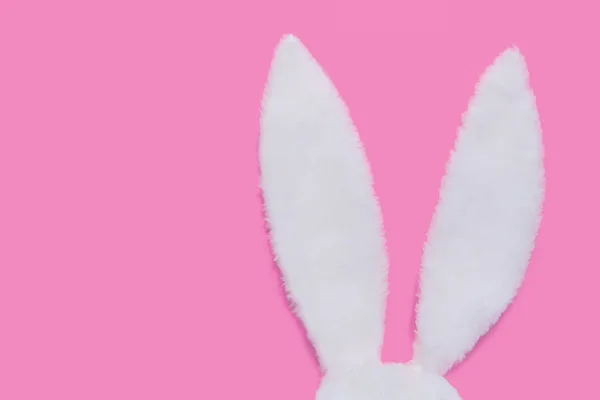 Oreilles de lapin en fourrure blanche sur fond rose pastel. Le concept de Pâques — Photo