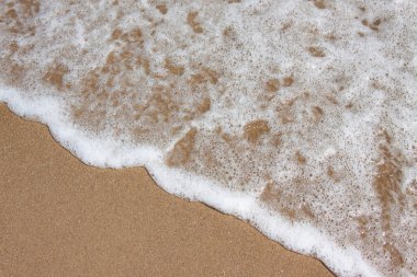 Kumlu bir plajda yumuşak deniz dalgası. güzel arka plan dokusu. metniniz için boş alan