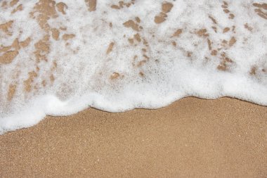 Kumlu bir plajda yumuşak deniz dalgası. güzel arka plan dokusu. metniniz için boş alan