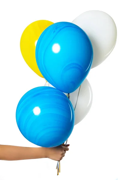 En hand håller ballonger. Isolering på vit bakgrund. blå vita och gula bollar. — Stockfoto