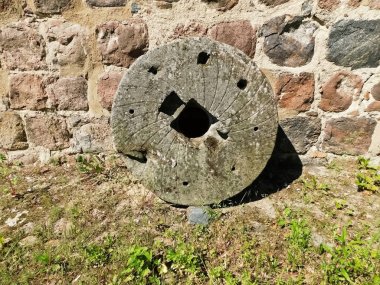 The millstone at the early Gothic church from the 13th century clipart