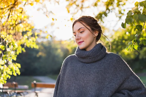 秋の公園でニットのセーターに頭の周りひもと美しいブルネット — ストック写真