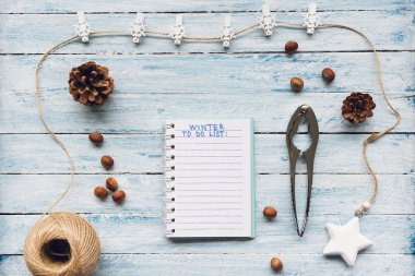 Notepad with Winter To Do List text on a blue and white wooden background. Top view, flat lay, mockup. Winter, Christmas and New Year celebration and resolutions concept. clipart