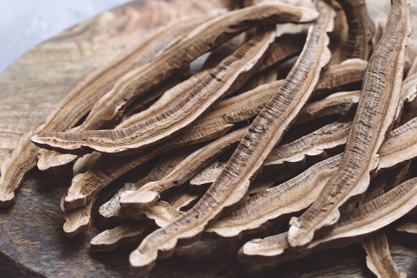 Slices of dried lingzhi mushroom, also called Reishi, on a woode