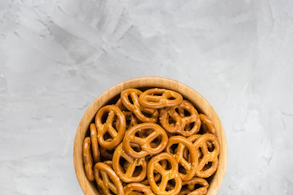 Traditionele zoute mini pretzels in houten kom op een grijze backrou — Stockfoto