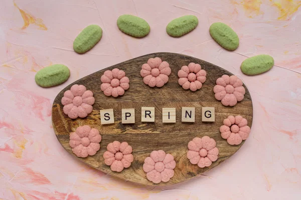 Wiosenne ciasteczka słowo i kwiat na płycie na różowy liczby — Zdjęcie stockowe