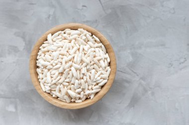 Gri bir arka plan üzerinde ahşap bir kapta kabarık pirinç