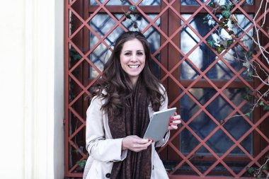 Dışarıda dijital tablet kullanan kız. İlkbahar veya sonbahar zamanı.