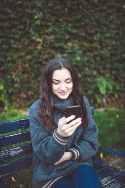 Açık havada akıllı telefonu olan genç kadın