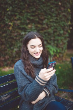 Açık havada akıllı telefonu olan genç kadın