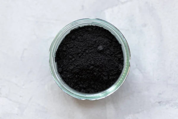 Black activated charcoal powder in a glass — Stock Photo, Image