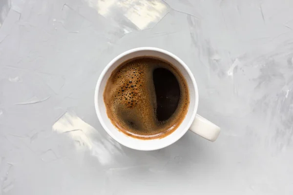 Cup of black coffee on light gray background