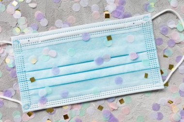 Mavi cerrahi maske ve renkli konfeti.