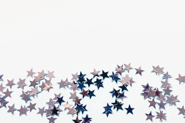 Estrelas de confete de folha de prata no fundo branco — Fotografia de Stock