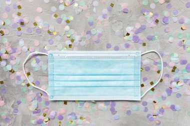 Mavi cerrahi maske ve renkli konfeti.