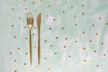 Altın çatal bıçak takımı ve yıldız konfetisi