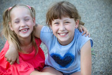 iki kız kız kucaklamak ve gülümse, kardeş, çocuk, yaz, yürüyüş, sevinç, sevimli küçük kız huggings açık havada. Dostluk kavramı.