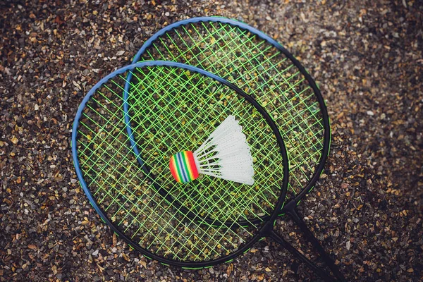 Rakiety do badmintona z białego shuttlecockon żwir Tłuczeń, dziecko gra — Zdjęcie stockowe