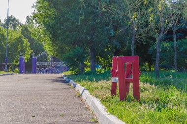Yolun yakınında parkta yalnız bir ahşap Bank