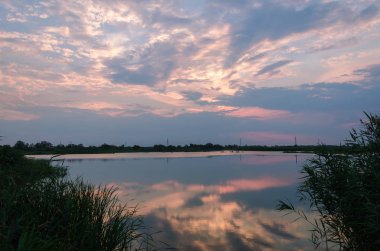 Sarı ve kırmızı günbatımı sakin bir nehir üzerinde akşam