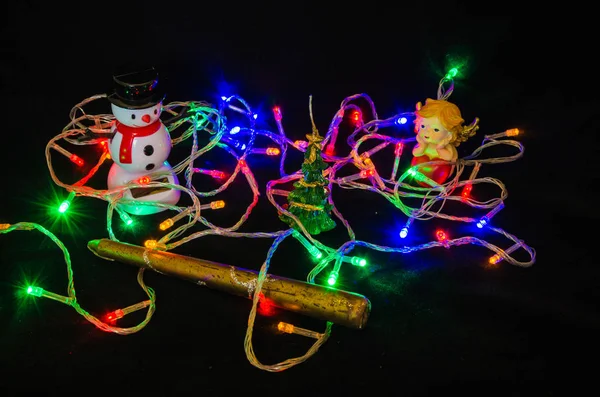 Noel ağacı garland, çam kozalağı, yılbaşı ağacı, kelebek, siyah bir zemin üzerine mum.