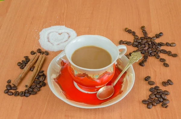 Bir fincan kahve ve kahve çekirdekleri ahşap zemin üzerine sütlü kahve.