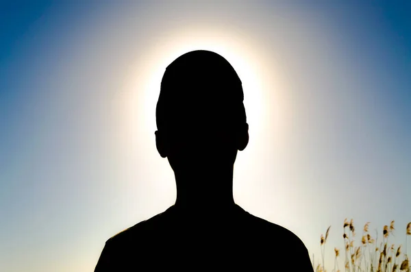 Parlak güneşin arka plan üzerinde bir çocuk figürü.