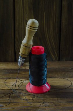 Naylon bir ahşap arka plan iş parçacığında yanında ayakkabı tığ.