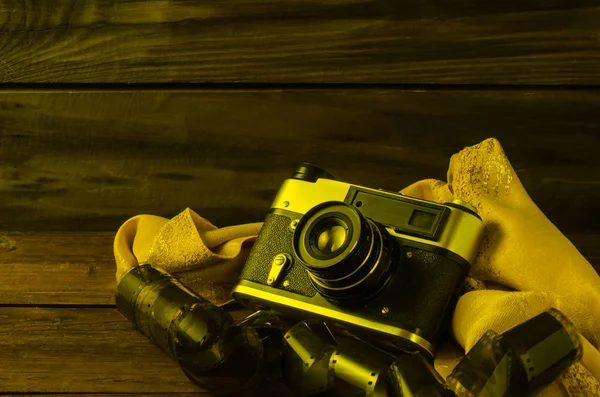 Photo film and film camera on a wooden table. — Stock Photo, Image