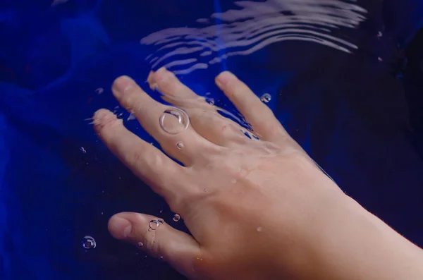Children's hands against the background of water and white. — Stock Photo, Image
